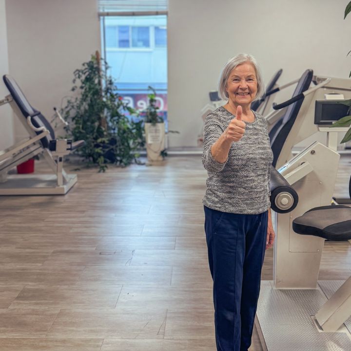 Seniori-ikäinen nainen tyytyväisenä harjoittelemassa Fit Lahti kuntokeskuksessa.