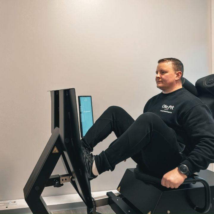 Fysioterapeutti näyttämässä HUR-jalkaprässin toimintaa Fit Lahdessa.